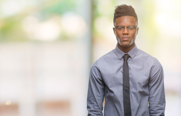 Young african american business man over isolated background with serious expression on face. Simple and natural looking at the camera.