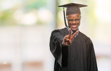 Young graduated african american man over isolated background smiling looking to the camera showing fingers doing victory sign. Number two.