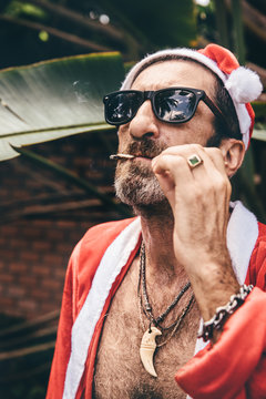 Santa smoking a cigarette in front of banana tree