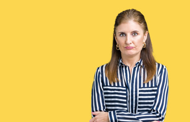 Middle age mature business woman over isolated background skeptic and nervous, disapproving expression on face with crossed arms. Negative person.