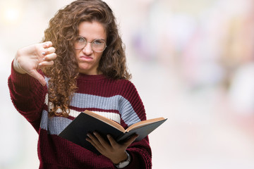 Young brunette girl reading a book wearing glasses over isolated background with angry face,...