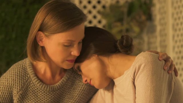 Two sisters supporting each other in grief, dealing with family loss, closeup