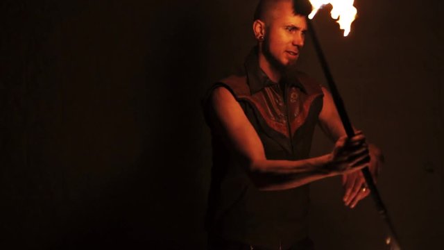 Slowmotion shot of man spinning staff with wall behind