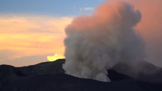 Mt Bromo at sunset an active volcano erupting smoke and ash Java