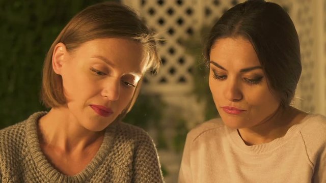 Two women gossiping, talking about close friends, jealous of success, closeup