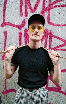 Cool looking twenties man wearing cap and yellow sunglasses
