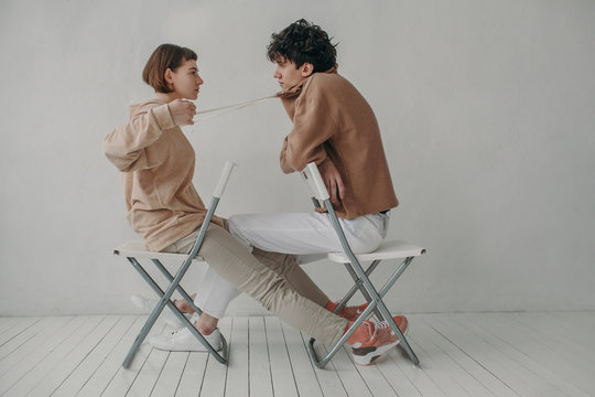 Woman pulling cord on hoodie of man
