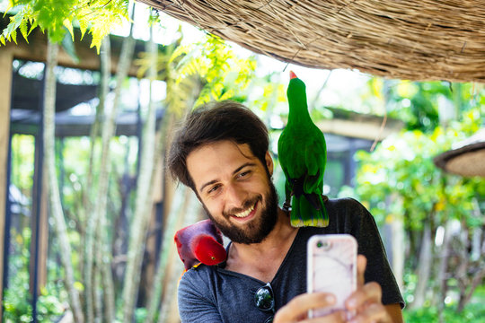 Man playing with tropical birds