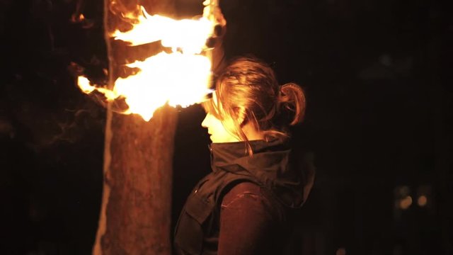Slowmotion medium shot of woman practising with fire fans