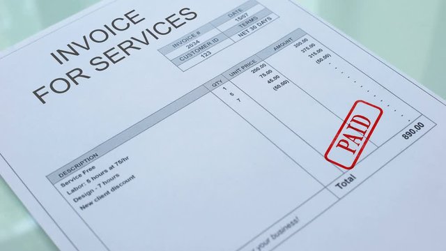 Invoice for service paid, hand stamping seal on commercial document, business