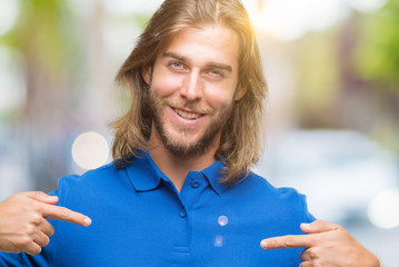 Young handsome man with long hair over isolated background looking confident with smile on face,...