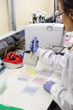 Female scientist using a pipette in a DNA laboratory