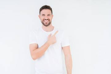 Young handsome man wearing casual white t-shirt over isolated background cheerful with a smile of face pointing with hand and finger up to the side with happy and natural expression on face