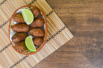 kibe - delicious brazilian salted on wooden table accompanied by lemons