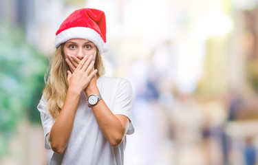 Young beautiful blonde woman wearing christmas hat over isolated background shocked covering mouth with hands for mistake. Secret concept.