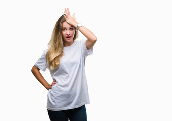 Young beautiful blonde woman wearing casual white t-shirt over isolated background surprised with...