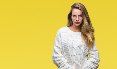 Young beautiful blonde woman wearing winter sweater and sunglasses over isolated background skeptic and nervous, frowning upset because of problem. Negative person.