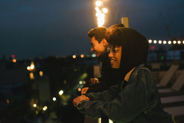 Friends hanging out on rooftop at night