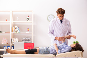 Male doctor checking joint flexibility with goniometer 