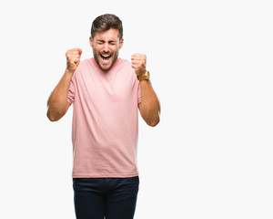 Fototapeta premium Young handsome man over isolated background excited for success with arms raised celebrating victory smiling. Winner concept.