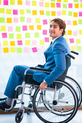 Young handsome man in wheelchair with many conflicting prioritie