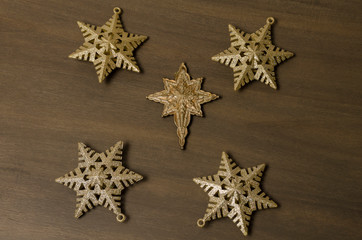 Fototapeta na wymiar Golden stars against wooden background. Golden stars for Christmas decoration. Christmas background