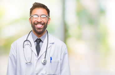 Adult hispanic doctor man over isolated background sticking tongue out happy with funny expression. Emotion concept.