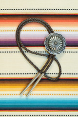 Vintage Sterling Silver Bolo Tie with Concho andSilver Tips on colorful southwestern hand woven fabric.