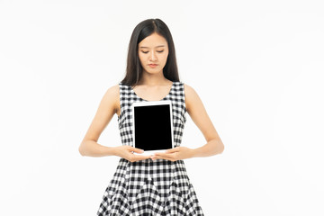 Naklejka premium smiling beautiful asian woman holding tablet computer isolated on a white background.