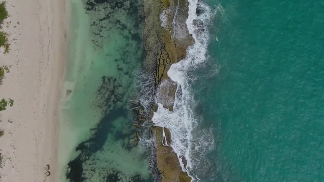 AERIAL: Birdseye view tracing the waves gently lapping over the lagoon at Yanchep, Western Australia.