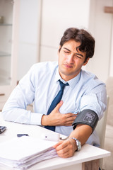 Man under stress measuring his blood pressure