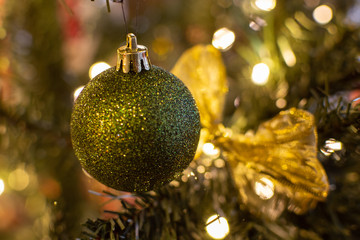 Green Christmas ball hanging on a tree
