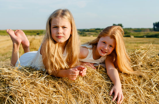 Portrait of two girls on the hay