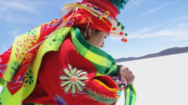 Traditional Bolivian dancing performed proudly by Indigenous South American female on Salar de Uyuni Salt flats wearing traditional costume 