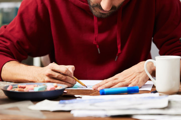 Midsection Of Man Using Pencil To Draw In Studio