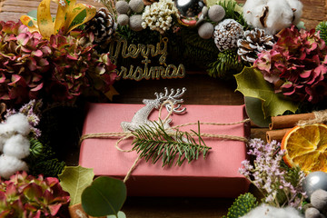 Wreath, gift box and pine cone on white wood for Christmas decor