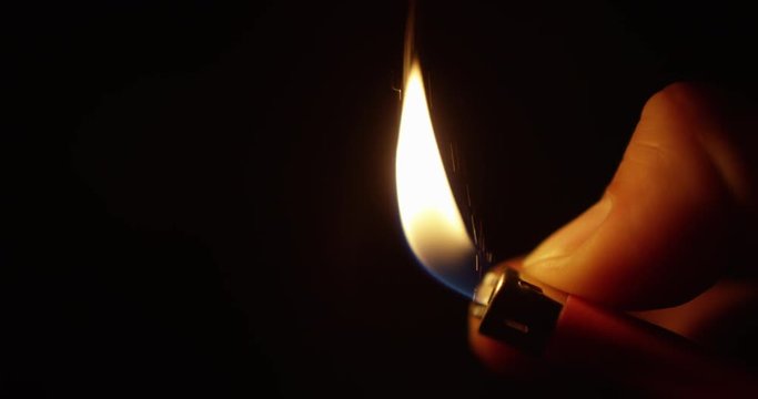 CLOSEUP IN SLOW MOTION OF A LIHTER SPARK WITH A BLACK BACKROUND