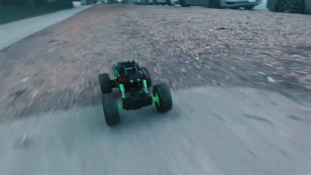 RC Truck driving outside, through neighborhood on dirt and sidewalks.