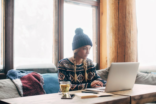 Woman Working on Her Laptop at Log Cabin