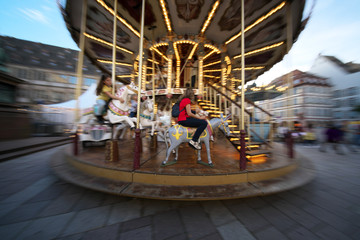 Strasbourg,France-October 12, 2018: Panning of people enjoying riding a merry-go-round