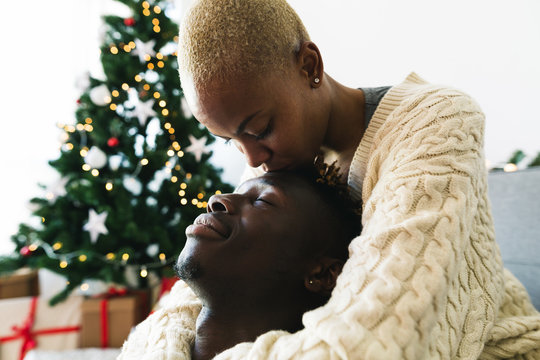 Young multiethnic lovers relaxed at home on Christmas.