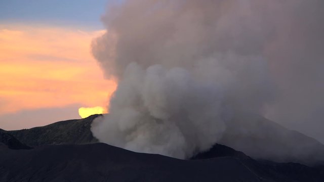Mt Bromo at sunset an active volcano erupting smoke and ash Java