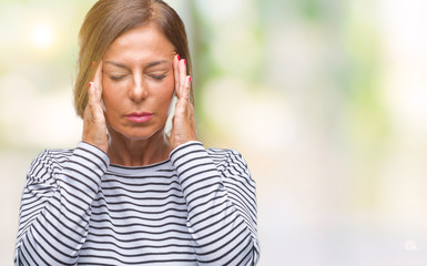 Middle age senior hispanic woman over isolated background with hand on head for pain in head because stress. Suffering migraine.