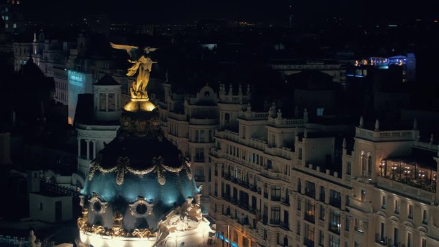 MADRID, SPAIN - JANUARY 17, 2018: Night cityscape with illuminated Metropolis Building. View to the dome with statue. City architecture
