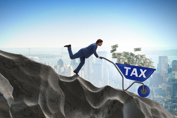 Businessman pushing wheelbarrow with tax money