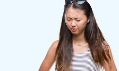 Obraz premium Young asian woman wearing sunglasses over isolated background with hand on stomach because indigestion, painful illness feeling unwell. Ache concept.