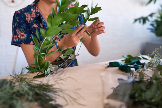 Christmas wreath making with fresh leaves and plants
