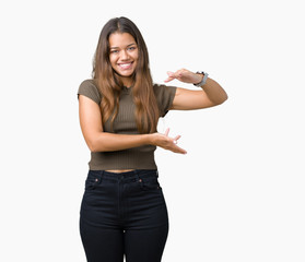 Young beautiful brunette woman over isolated background gesturing with hands showing big and large size sign, measure symbol. Smiling looking at the camera. Measuring concept.