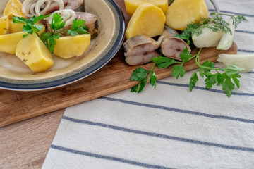 Sliced fish with potatos on plate