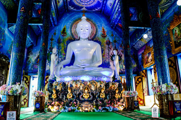 Fototapeta premium White Buddha statue in blue temple with beautiful Thai handicraft pattern.Thailand Chiang rai : 9 November 2018